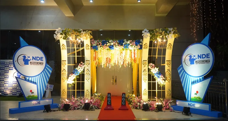 Gold draped entrance arch with backlit branding for an NDE corporate gala