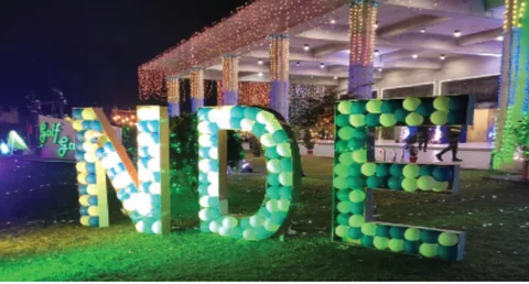 Illuminated NDE letter installation in a landscaped garden at night