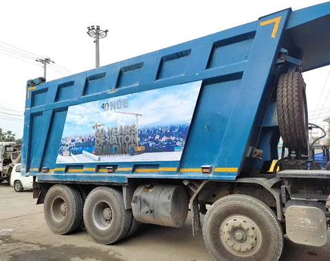 Large-format vehicle graphics applied to a construction dump truck